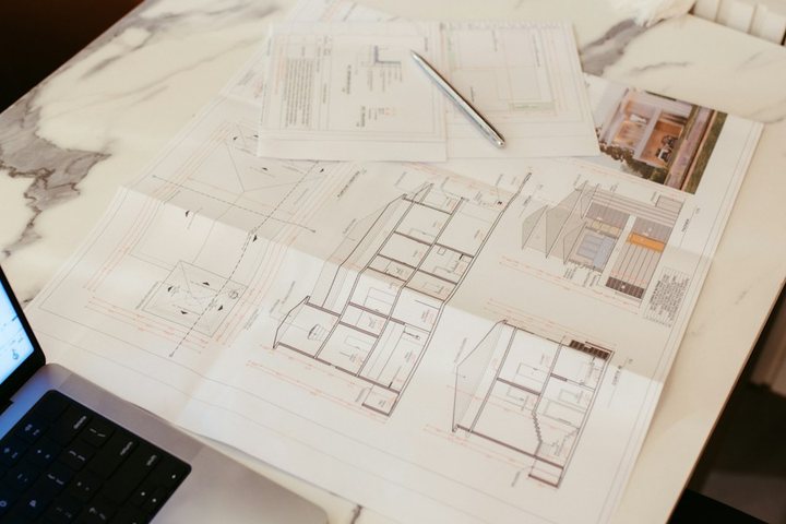 Architectural plans and laptop on a desk